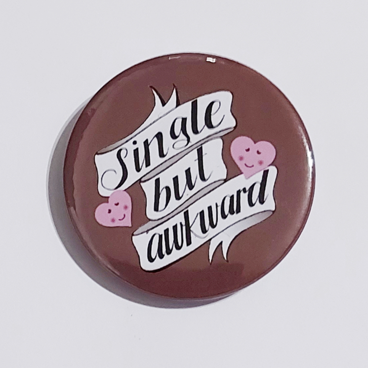 Badge with a brown background that reads "Single but awkward"