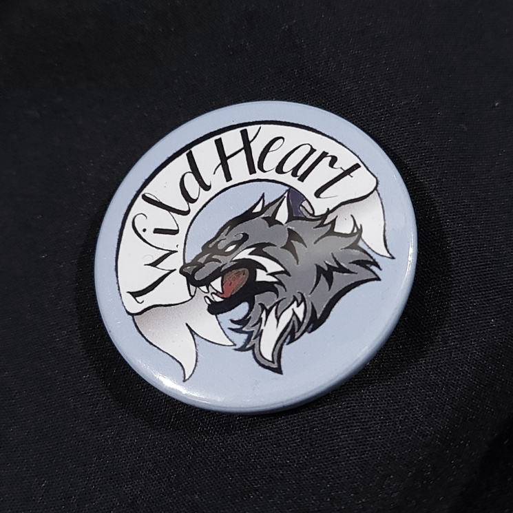Pinback badge with banner reading "Wild Heart" and a snarling wolf