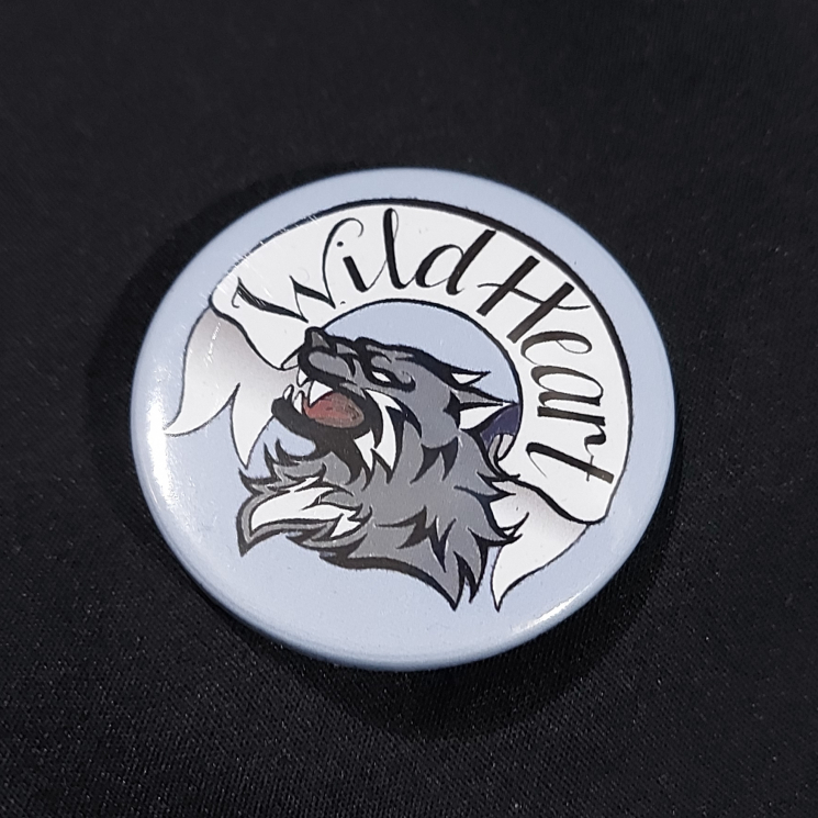 Pinback badge with banner reading "Wild Heart" and a snarling wolf