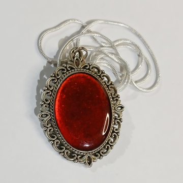 Silver pendant with glowing red stone